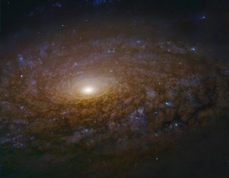 A whirlpool of stars in outerspace, with a bright planet or star in the center.